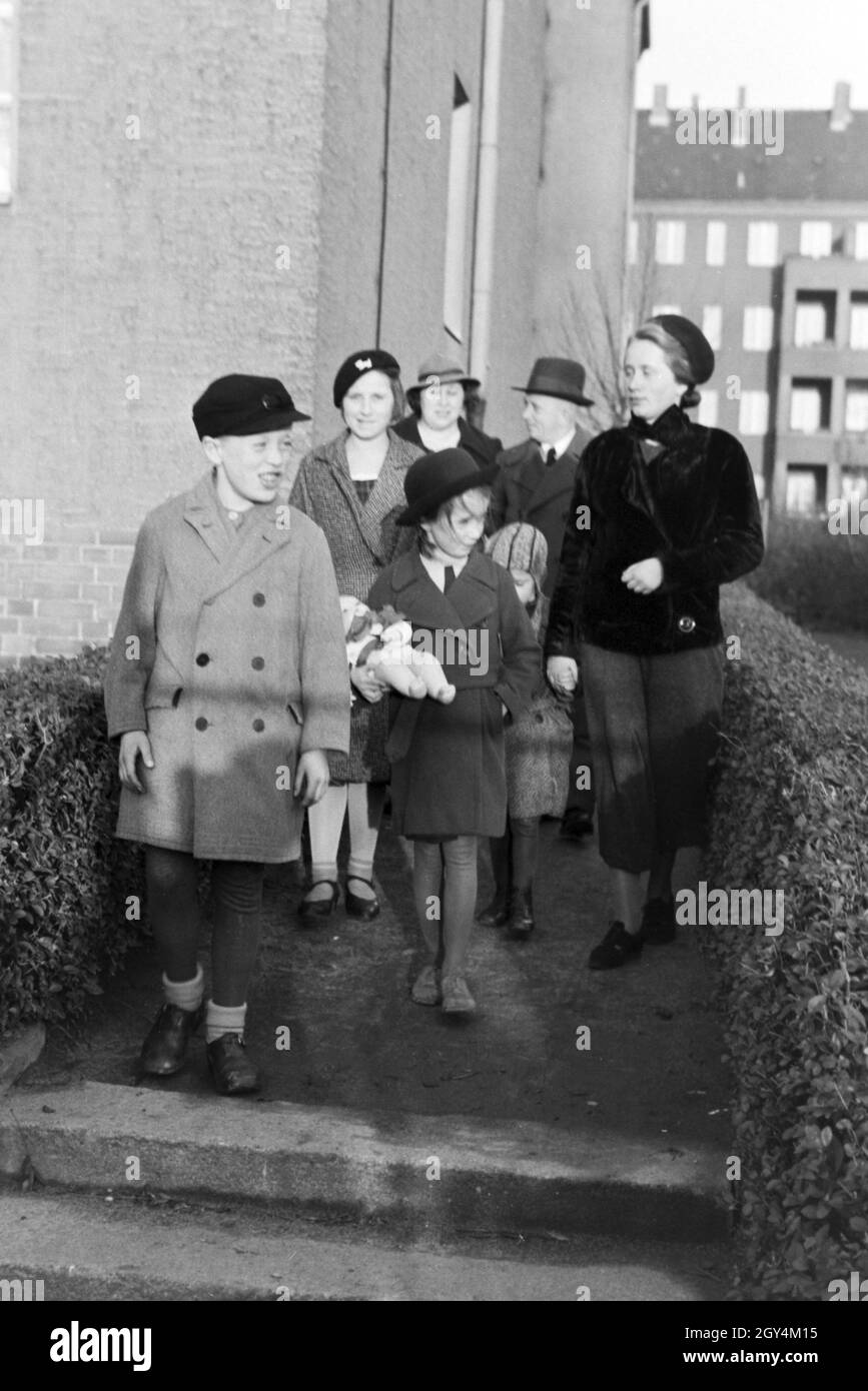 Die Mitglieder einer kinderreichen Familie auf dem Weg zur Verleihung des Ehrenkreuzes, Deutsches Reich 1930er Jahre. I membri di una famiglia estesa di andare per la concessione oh l'onore Croce, Germania 1930s. Foto Stock