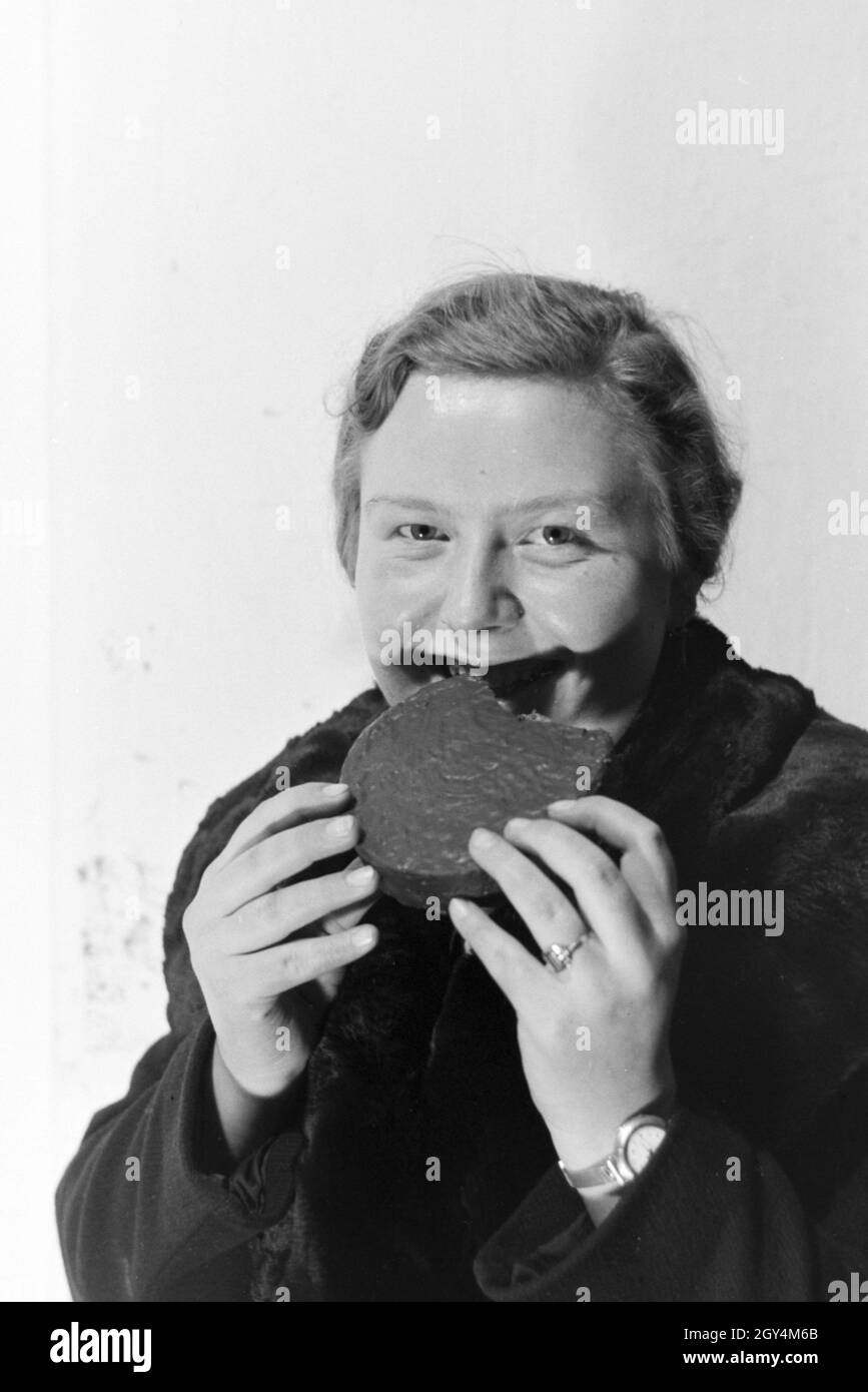 Eine Kundin probiert einen Pfefferkuchen, Deutsches Reich 1930er Jahre. Un cliente degustazione di panpepato, Germania 1930s. Foto Stock