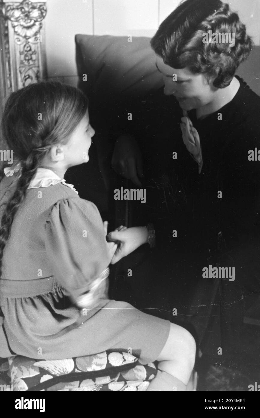Mitglieder einer kinderreichen Familie helfen sich gegenseitig, Deutsches Reich 1930er Jahre. I membri di una famiglia estesa si aiutano a vicenda, Germania 1930s. Foto Stock