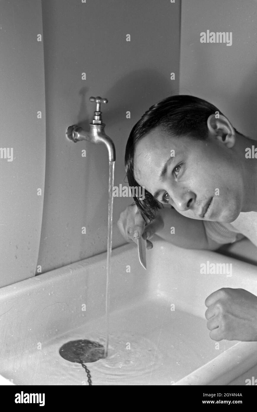 Ein Mann bei der Morgentoilette am Waschbecken, Deutschland 1930er Jahre. Un uomo con il bagno al mattino, Germania 1930s. Foto Stock