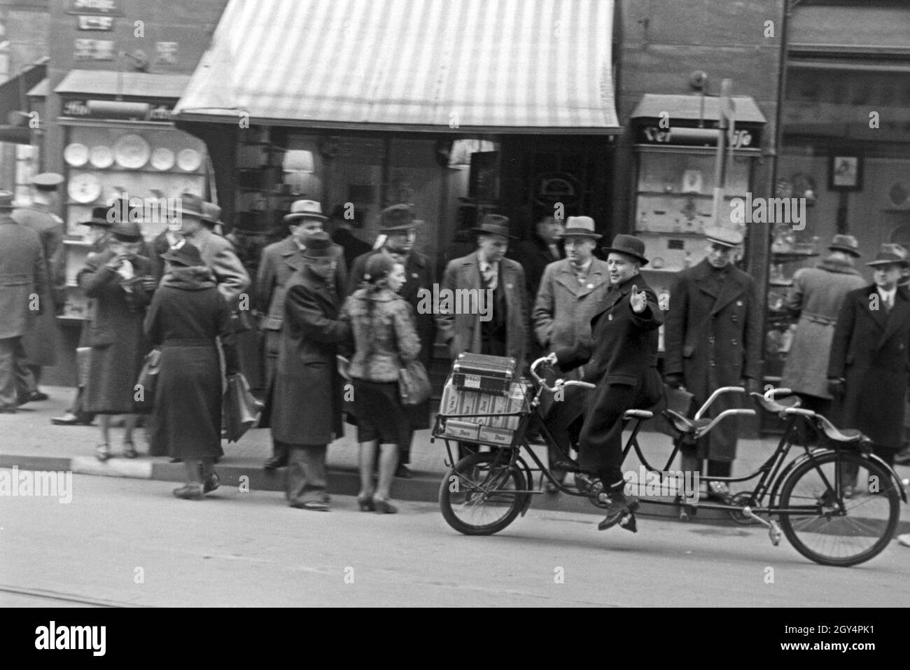 Ein Mann auf einem Tandemfahrrad in der Innenstadt von Leipzig Zur Zeit der Messe, Deutschland 1940er Jahre. Un uomo su una bicicletta in tandem nella città di Lipsia durante la fiera, Germania 1940s. Foto Stock