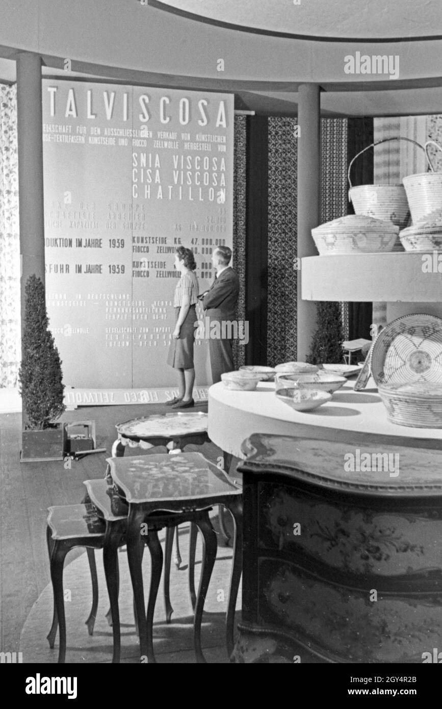 Angestellte des Italvicosa Messestands auf der Messe in Lipsia mit Ausstellungsstücken, Deutschland 1940er Jahre. I membri del personale su uno stand di Italviscosa con mostre, Germania 1940s. Foto Stock