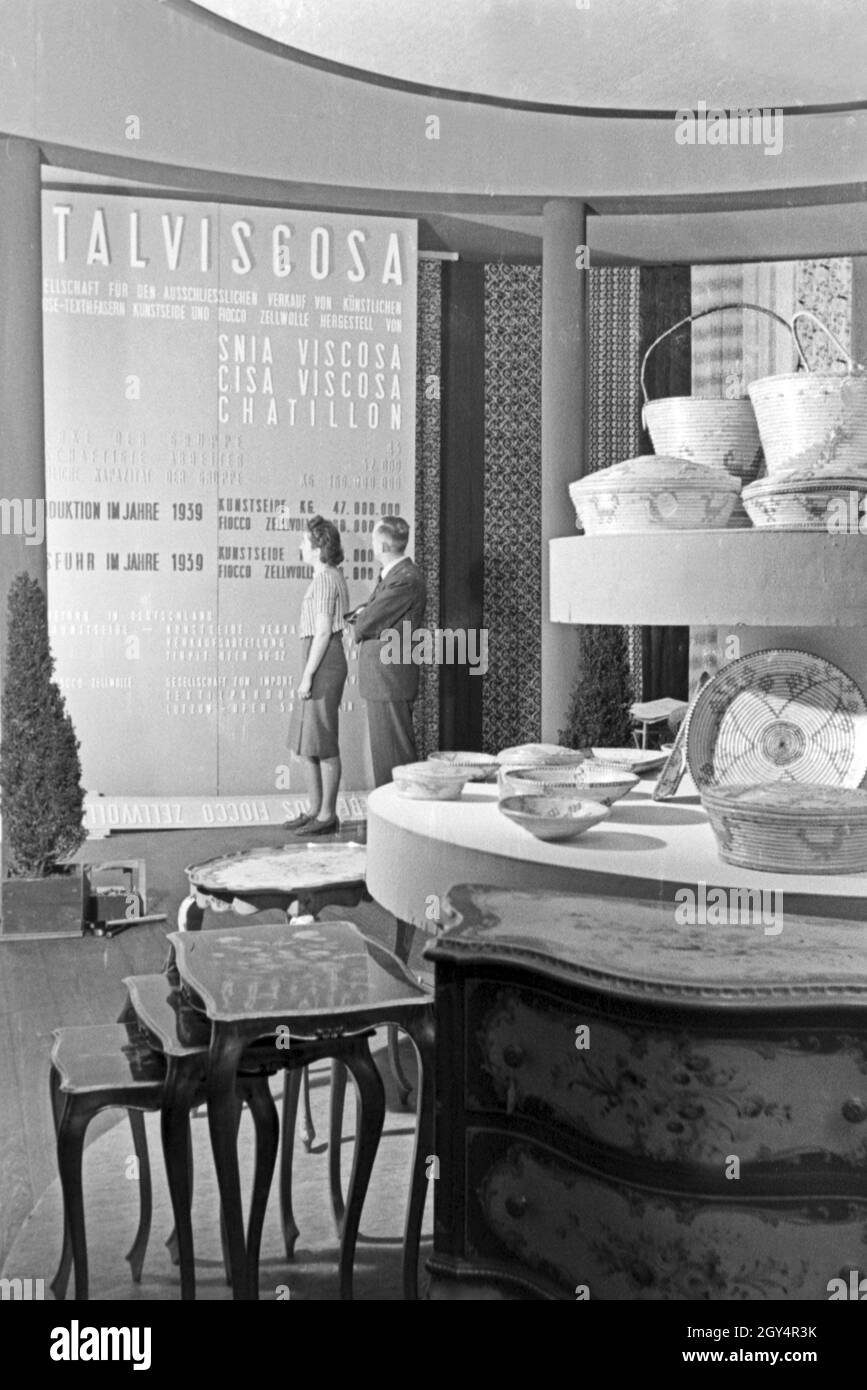 Angestellte des Italvicosa Messestands auf der Messe in Lipsia mit Ausstellungsstücken, Deutschland 1940er Jahre. I membri del personale su uno stand di Italviscosa con mostre, Germania 1940s. Foto Stock