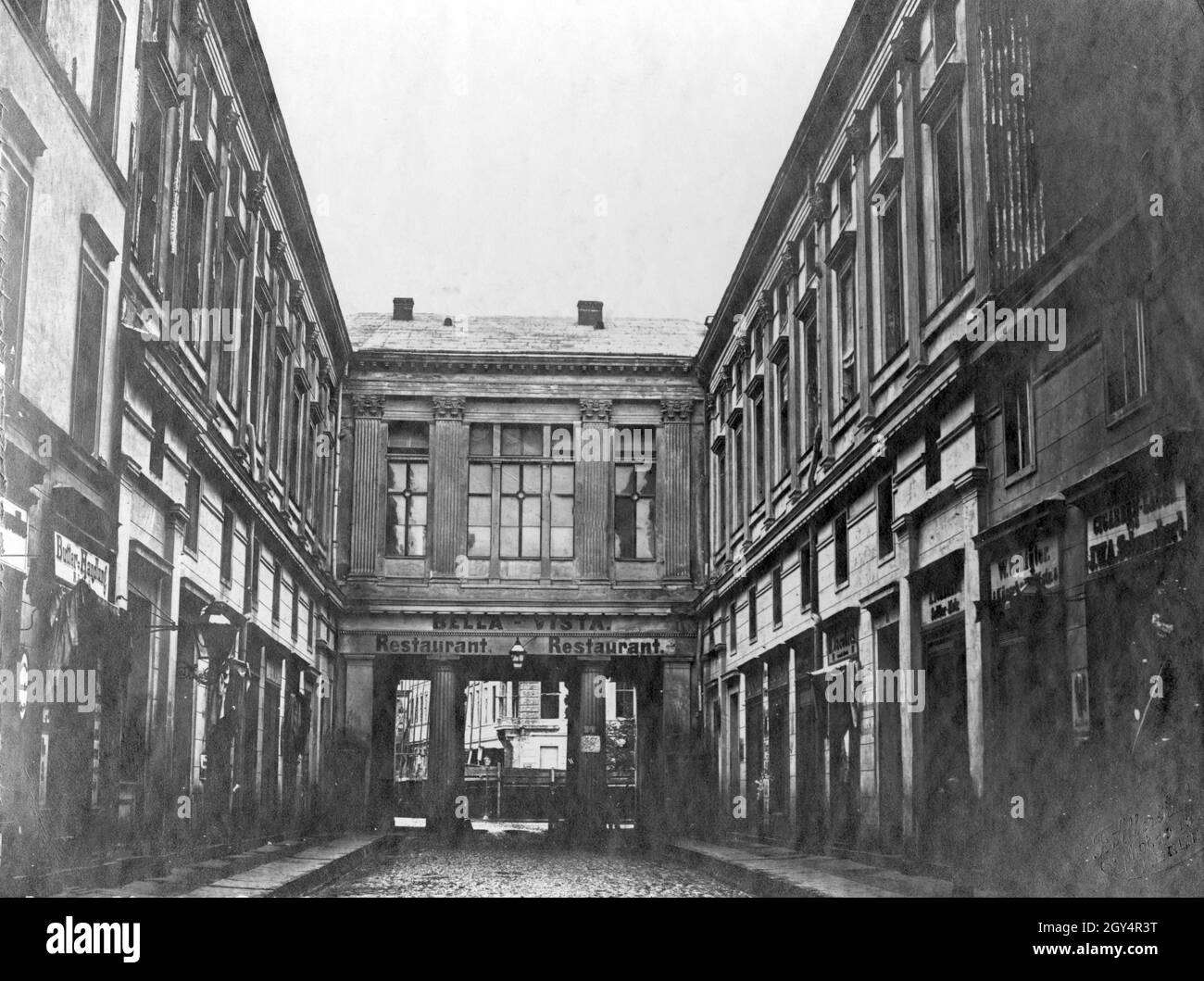 'La fotografia mostra il retro dell'edificio con la casa numero 76 in via Unter den Linden a Berlino, che aveva un passaggio nel Neue Wilhelmstraße (oggi Wilhelmstraße) e in cui si trova il ristorante ''Bella-Vista'. Questa fotografia è stata presa da Wilhelmstraße nel 1860. Sulla sinistra si trova un negozio di burro, sulla sinistra in negozio di W. Schlüter e un ''Cigarren-Lager'' di J.W.A. Schwarzbart. [traduzione automatizzata]' Foto Stock