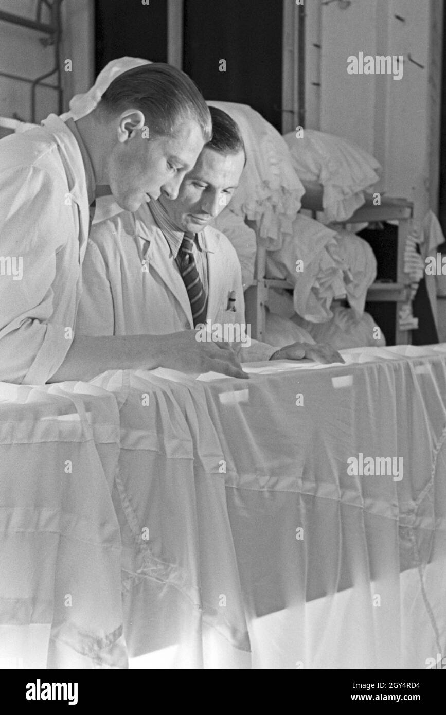 Zwei Vorarbeiter in einer Fallschirm Näherei, Deutschland 1940er Jahre. Due headmen in corrispondenza di un paracadute di fabbrica di cucitura, Germania 1940s. Foto Stock