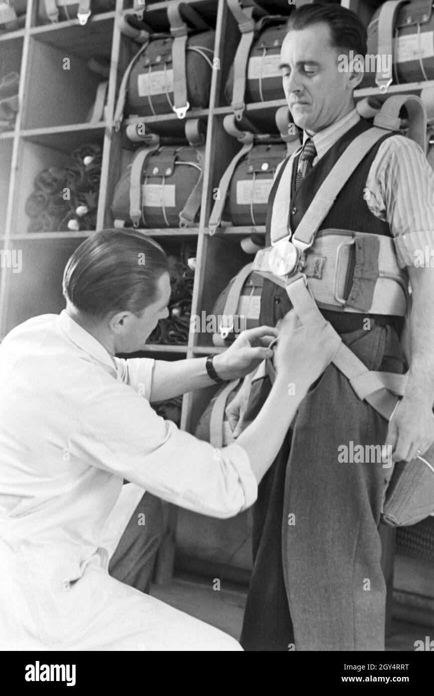 Anpassung des Gurtzeugs eines Fallschirms in einer Fallschirm Näherei, Deutschland 1940er Jahre. Controllare il cablaggio di un paracadute ad un paracadute di fabbrica di cucitura, Germania 1940s. Foto Stock