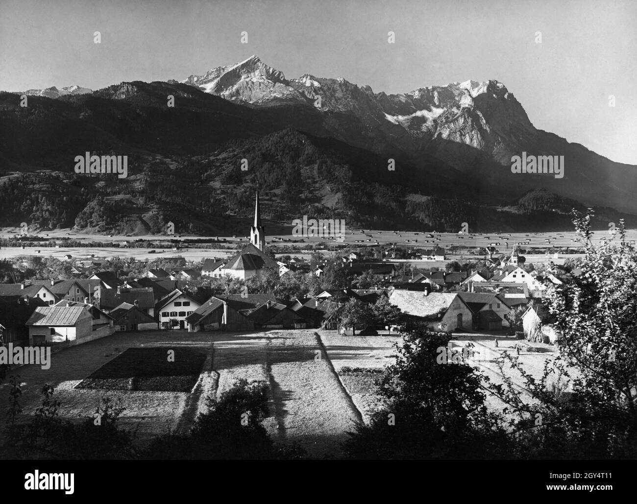 'La fotografia mostra Garmisch-Partenkirchen (distretto di Partenkirchen) intorno all'anno 1900. Al centro del paese si trova la chiesa parrocchiale Maria Himmelfahrt. Sul retro a destra si trova la ''Villa Christina'' (Schnitzschulstraße n° 19, con torre d'angolo), costruita nel 1893 dal produttore di sigari di Mannheim Georg Ludwig Mayer-Doss. Alle sue spalle si vedono i monti Wetterstein con Kreuzjoch, Alpspitze, Höllentalspitzen, Zugspitze, Waxenstein (da sinistra a destra). Foto dalla casa editrice d'arte di Max Stuffler da Monaco. [traduzione automatizzata]' Foto Stock