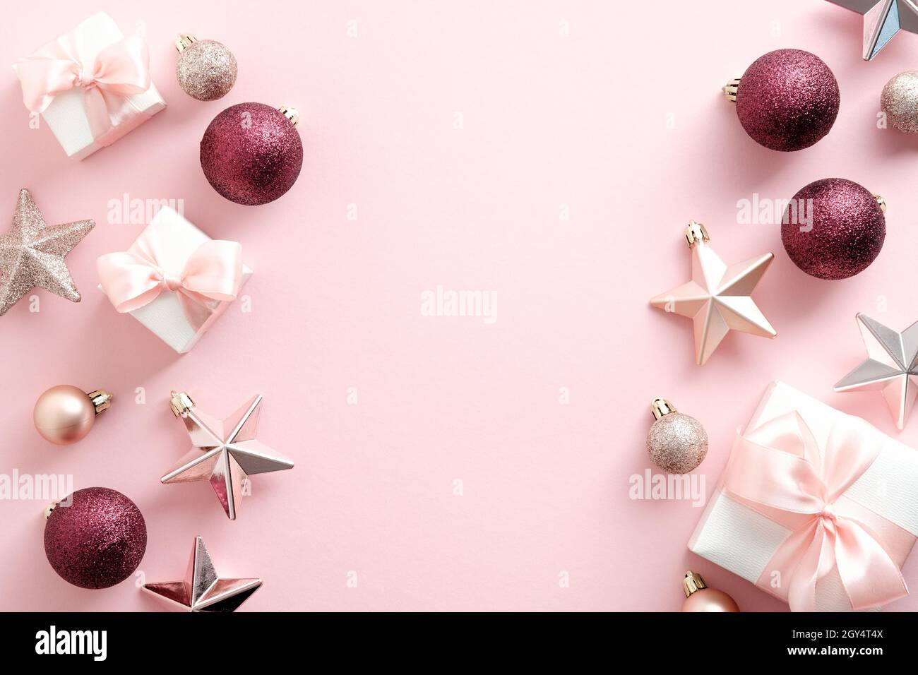 Elegante composizione a base di piatti natalizi con decorazioni natalizie, confezioni regalo, stelle su sfondo rosa pastello. Bellezza blog di Natale banner design. F Foto Stock