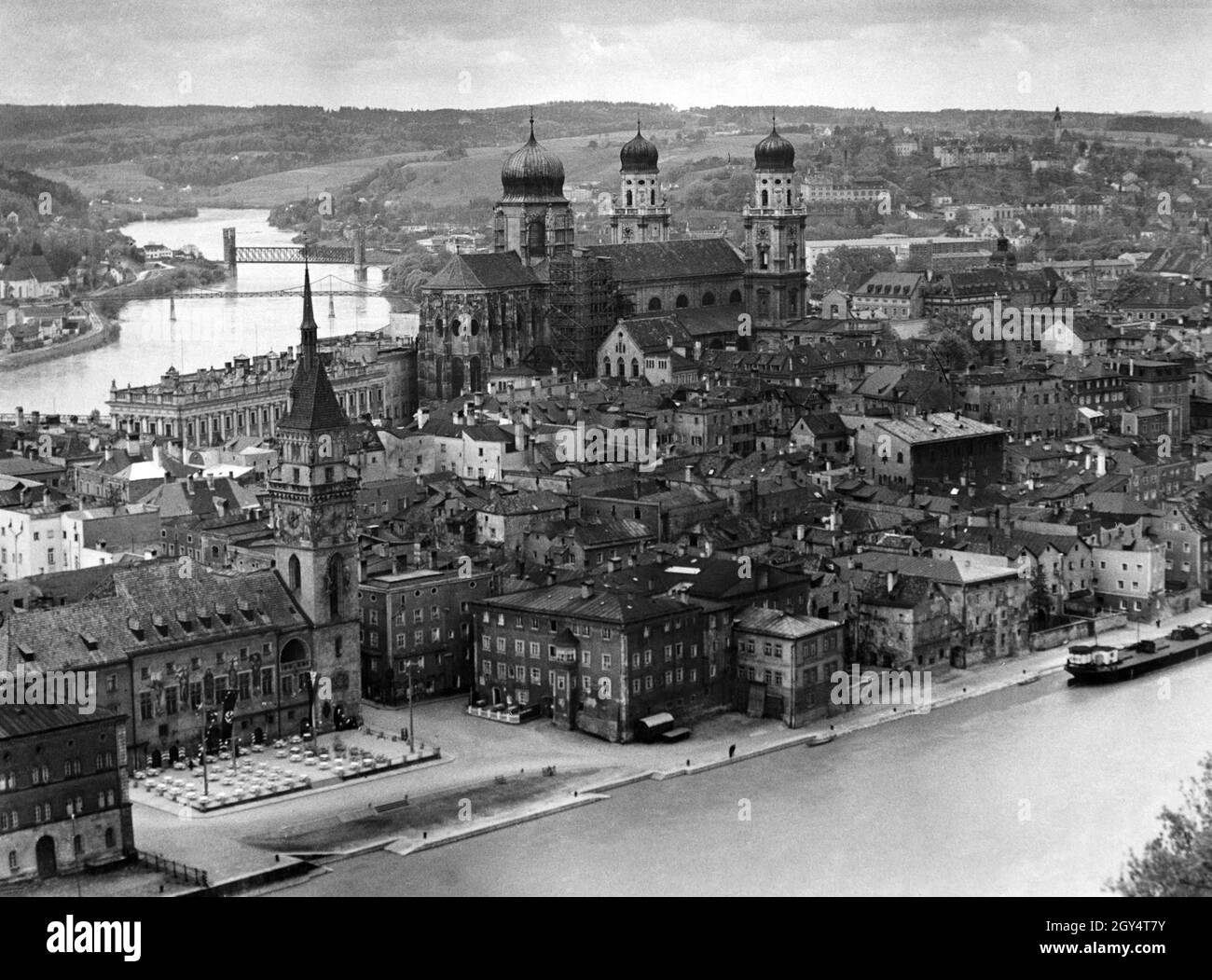 La vista nel 1937 dal teste Oberhaus è della penisola tra il Danubio (a destra) e la locanda (a sinistra), su cui si trova il centro storico di Passau. La Fünferlsteg alla chiesa di San Severin (all'estrema sinistra) e la Kaiserin-Elisabeth-Brücke per la ferrovia conducono attraverso la locanda. Nel centro storico si trova la torre del municipio presso il vecchio municipio (fronte sinistro), di fronte al quale sono stati allestiti tavoli per una festa. Alla Cattedrale di Santo Stefano (centro di foto) si trova un ponteggio in legno per lavori di ristrutturazione. [traduzione automatizzata] Foto Stock