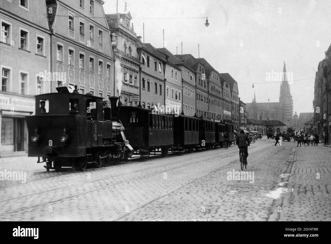 'In tempi precedenti una ferrovia a scartamento ridotto ha portato dalla strada principale del distretto di Ratisbona Stadtamhof (nella foto) al memoriale di Walhalla. Sulla sinistra, nella via dello shopping, troverete il 'Marien-Apotheke'. Sullo sfondo, i passanti si dirigono verso il 'Steinerne Brücke' (Ponte di pietra), che conduce al centro storico di Ratisbona con la cattedrale, attualmente in fase di ristrutturazione. [traduzione automatizzata]' Foto Stock