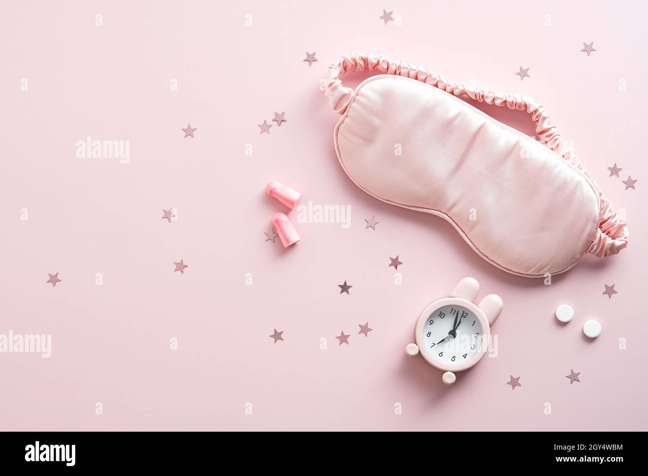 Flat Lay sleep eye mask, sveglia, tappi per le orecchie, pillole su sfondo  rosa. Accessori per il trattamento dell'insonnia Foto stock - Alamy