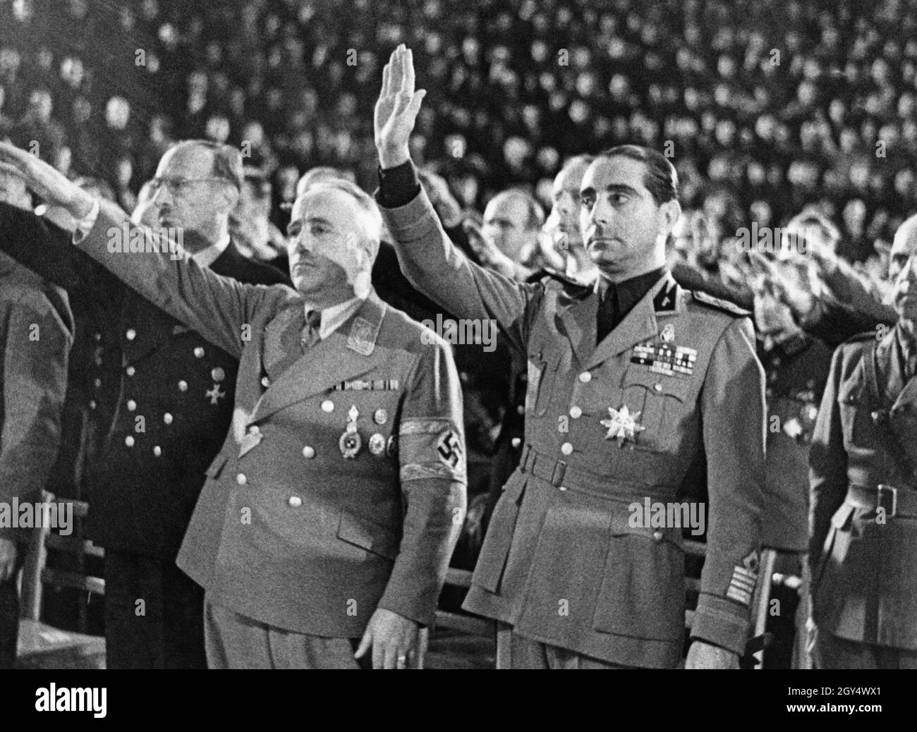 Il 28 ottobre 1943, 21° anniversario della marcia a Roma, il Fascio di Berlino ha tenuto una cerimonia al Kuppelsaal del Reichssportfeld (oggi Sportpark Berlin Kuppelsaal per le Olimpiadi). La foto mostra (da sinistra a destra) il Segretario di Stato Wilhelm Keppler, il Direttore dell'Organizzazione Reich Robert Ley, l'Ambasciatore Filippo Anfuso alzando le mani rispettivamente nel saluto Hitler e nel saluto romano, mentre gli inni nazionali di Germania e Italia sono stati suonati per concludere l'evento. Era presente anche il generale Aldo Principalle (indietro a destra, metà tagliata). I rappresentanti italiani lo erano Foto Stock