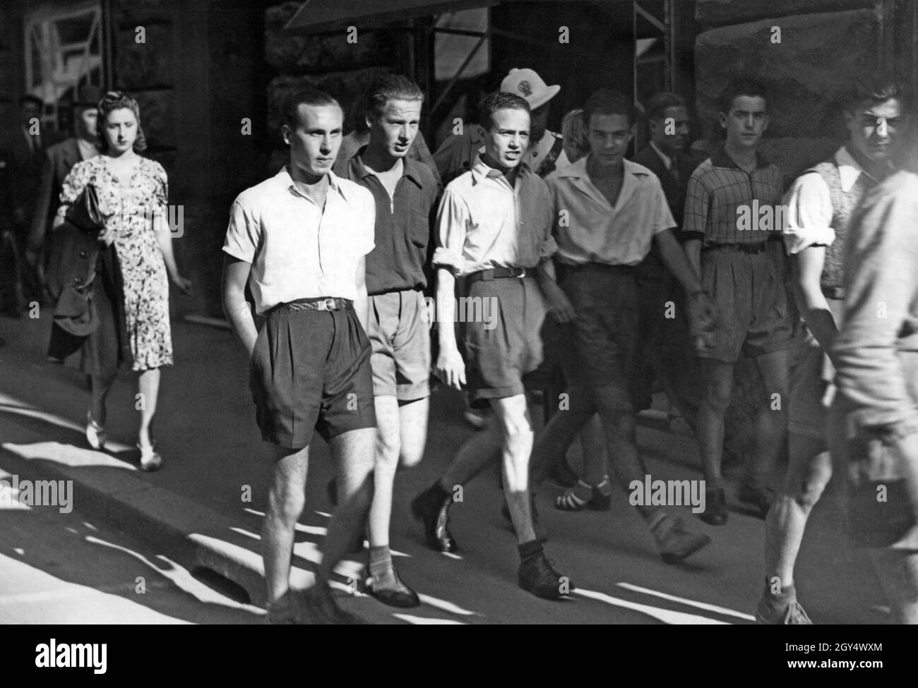 Nel 1940 fu data una nuova moda ai giovani italiani: Non si indossavano più abiti non essenziali come le cravatte. Si indossavano solo calzini corti e i ragazzi indossavano pantaloncini, come si vede nella foto, che probabilmente è stata presa a Roma. Questo era quello di salvare i tessili per l'economia di guerra. [traduzione automatizzata] Foto Stock