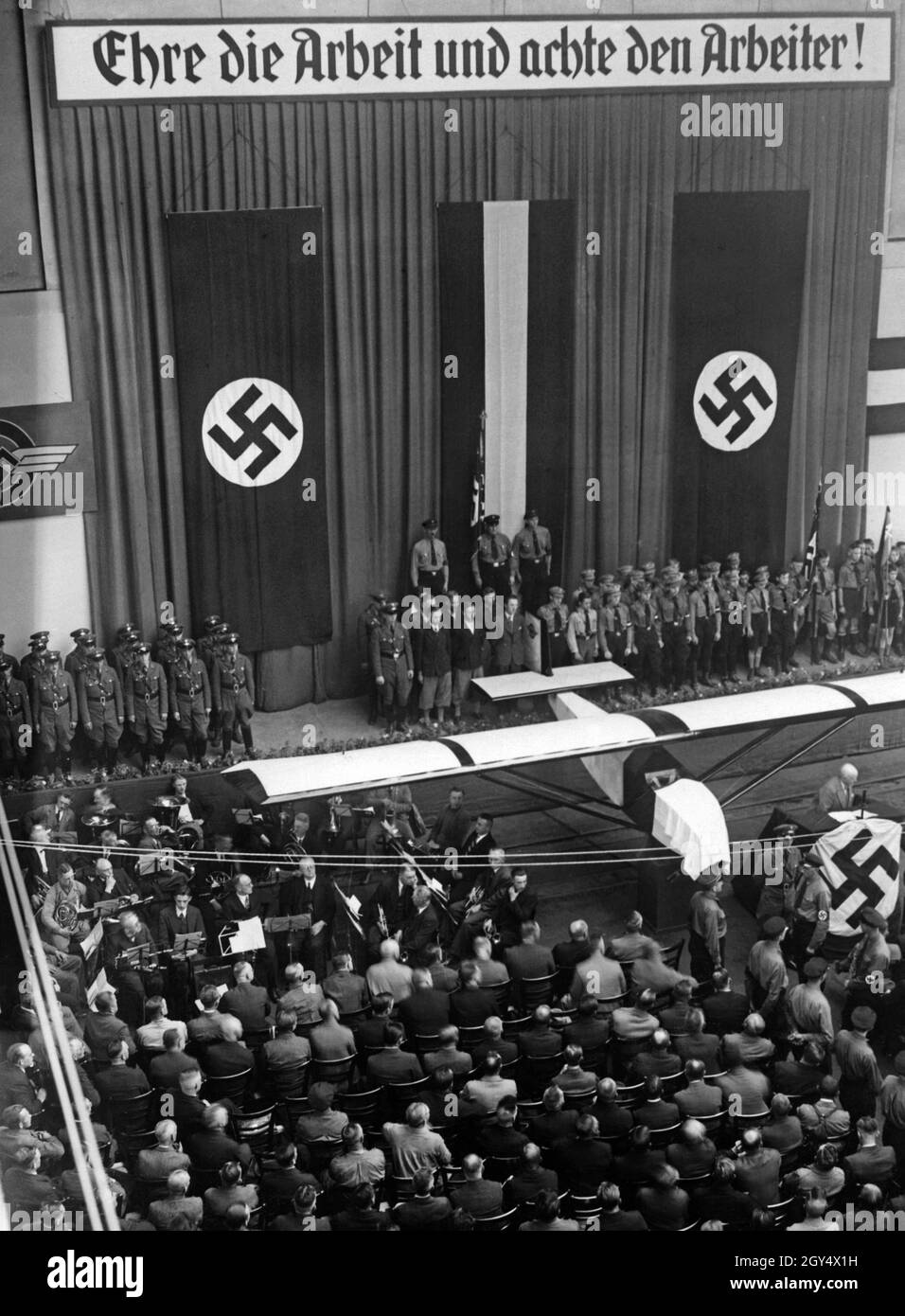 "Sbirciate al battesimo di un aliante alle Borsig Works di Berlino. Lo slogan ''onorare il lavoro e rispettare il lavoratore'' si aggancia al di sopra della scena. [traduzione automatizzata]' Foto Stock