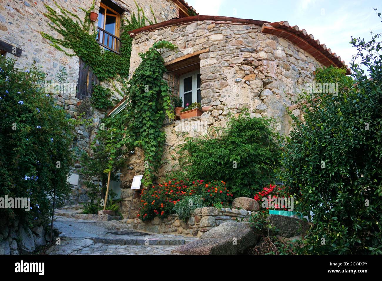 Casa exteriors adornato con piante rampicanti e fiori in fiore nella città di Eus, dipartimento Pyrénées-Orientales, Francia Foto Stock