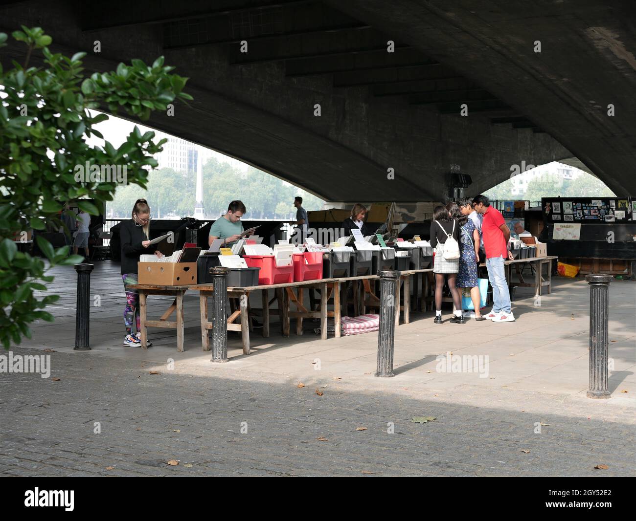 Shopping e navigazione al South Bank Book Market sotto Waterloo Bridge Foto Stock