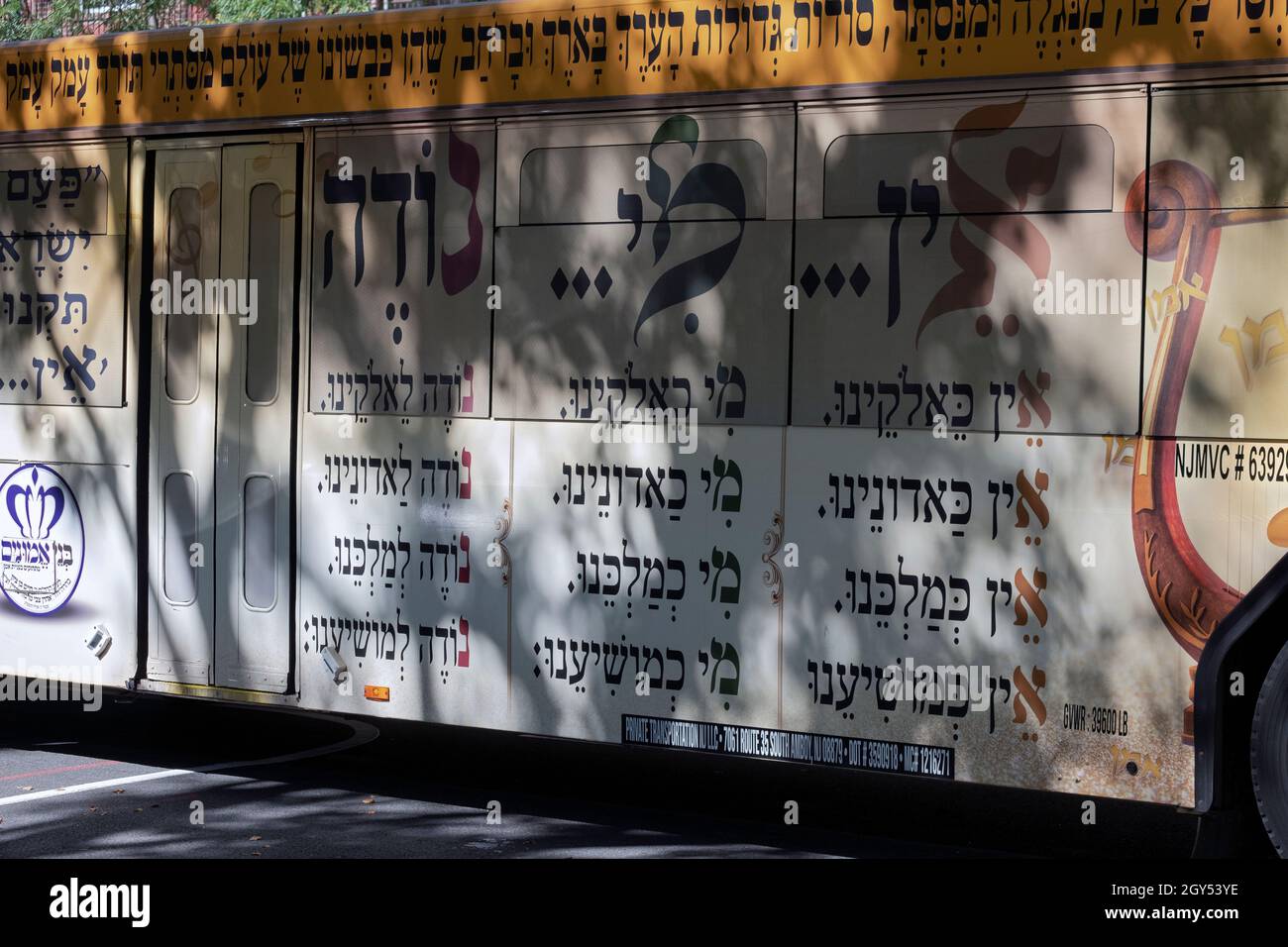 Versetti dalle preghiere ebraiche che lodano Dio su un autobus privato che trasporta le persone da Williamsburg ot Boro Park. Su Lee Ave. A Williamsburg, Brooklyn. Foto Stock