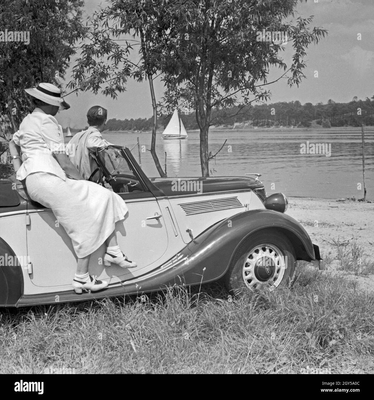 Werbefoto für den Personenkraftwagen Ford Eifel Mit einem Paar über einen Fluß schauend, Deutschland 1935. Fotografia commerciale per le automobili Ford Eifel con coppia guardare su un fiume, Germania 1935. Foto Stock