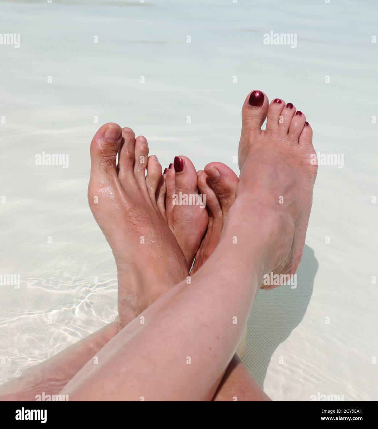 Quattro piedi di marito e moglie rilassarsi nella piscina del Resort Foto Stock