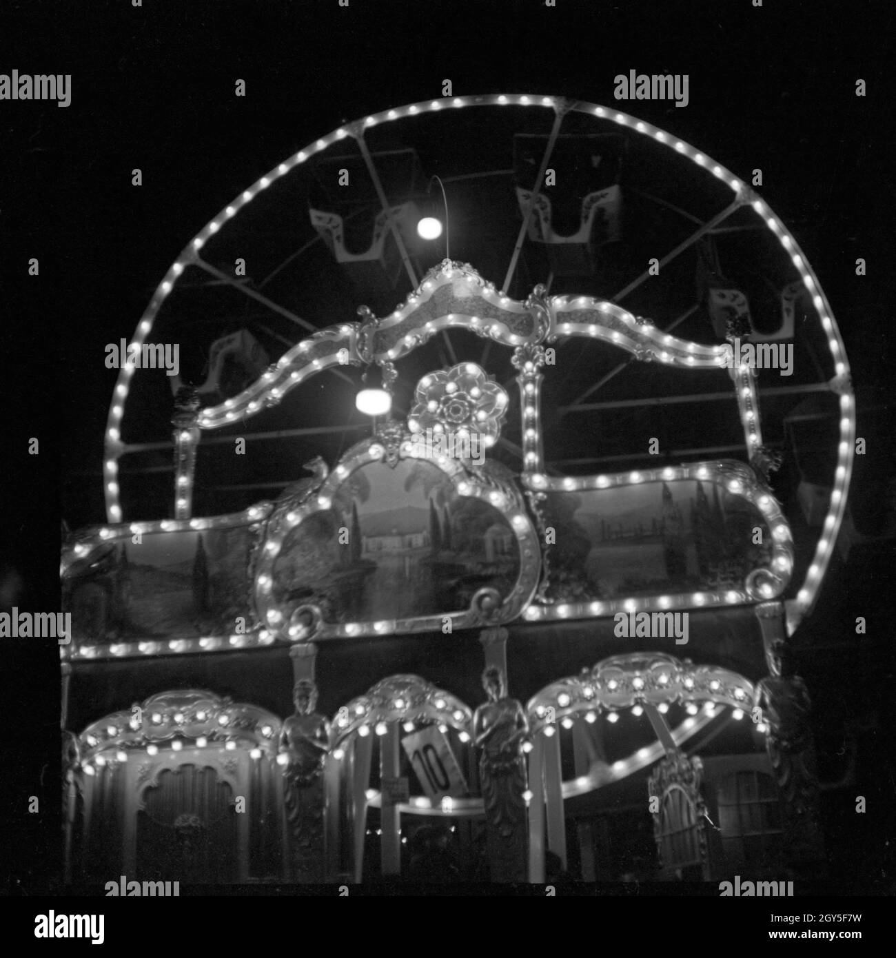 Ein kleines Riesenrad auf dem Weihnachtsmarkt am Abend, Deutschland 1930er Jahre. Un po' di ruota panoramica Ferris al mercatino di natale di notte, Germania 1930s. Foto Stock