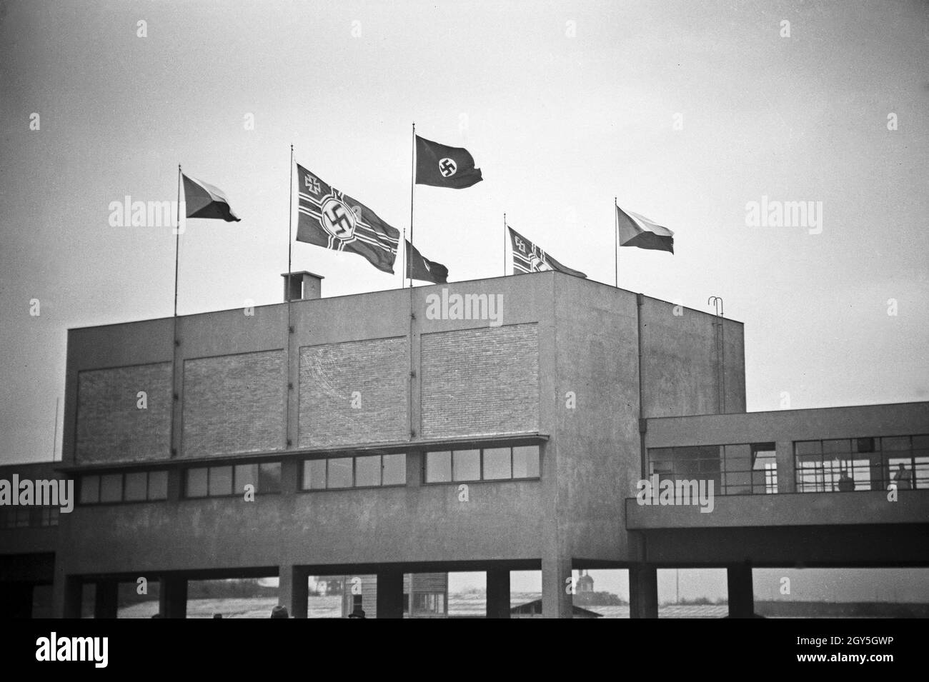 Originalbildunterschrift: Prag, em 20. Aprile im Sokol Stadion, WO die Geburtstagsfeier stattfand, zum ersten maschio die Hakenkreuzfahne, rechts und links die tschechische Fahne, 1930er Jahre. Foto Stock