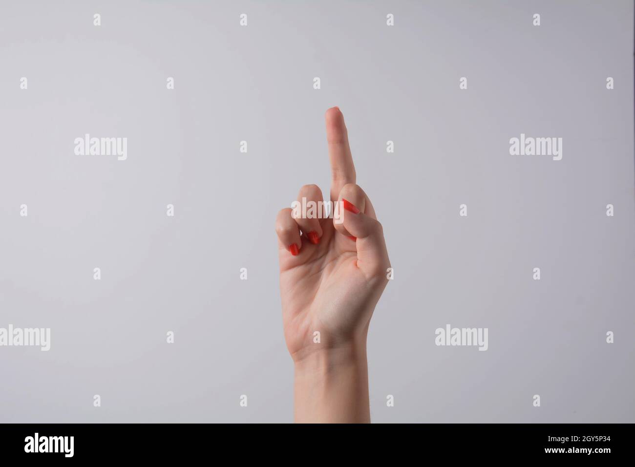 Mano che punta verso l'alto il dito medio, concetto di segno di mano rude o gesto della mano, isolato Foto Stock
