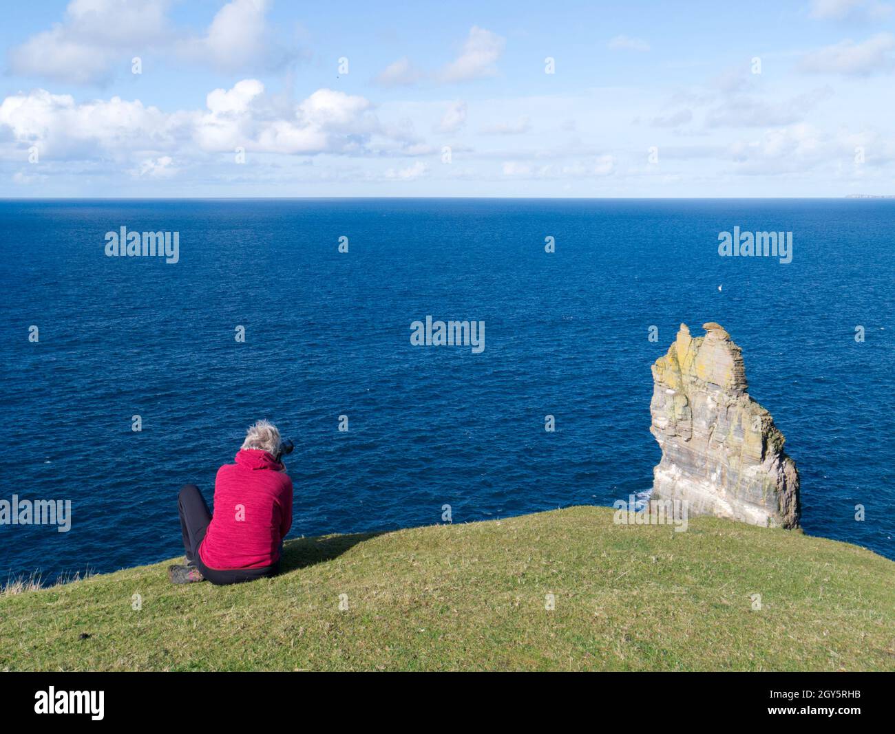 Fotografo sulla scogliera di Orkney, Scozia Foto Stock