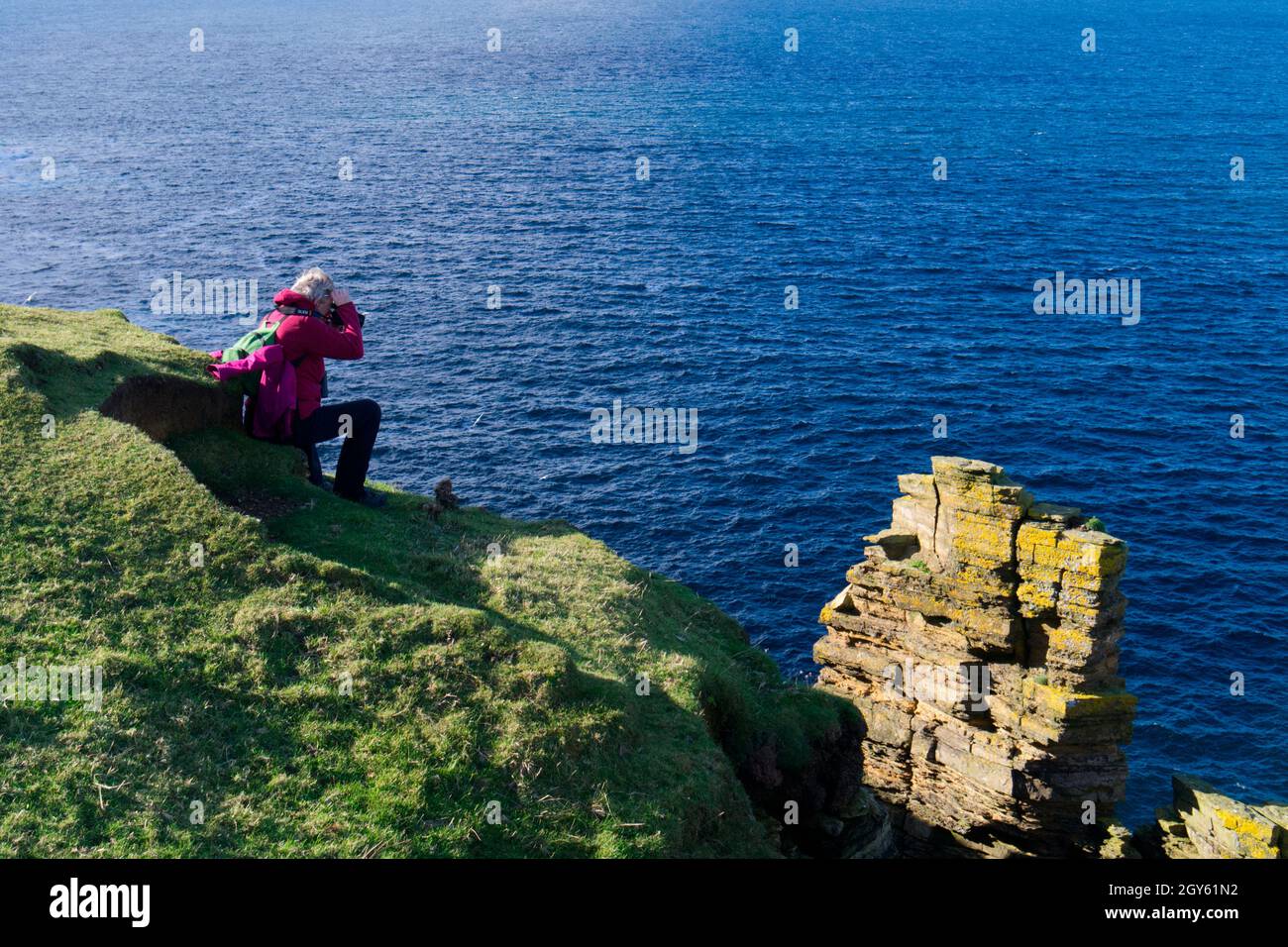 Fotografo sulla scogliera di Orkney, Scozia Foto Stock