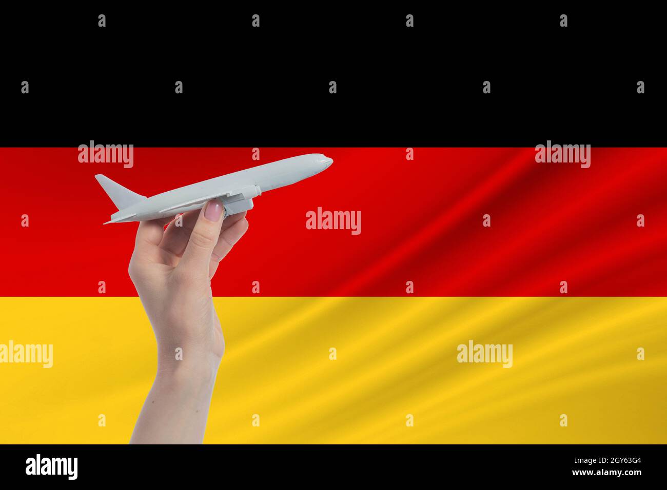 Aereo in mano con bandiera nazionale della Germania. Viaggio in Germania. Foto Stock