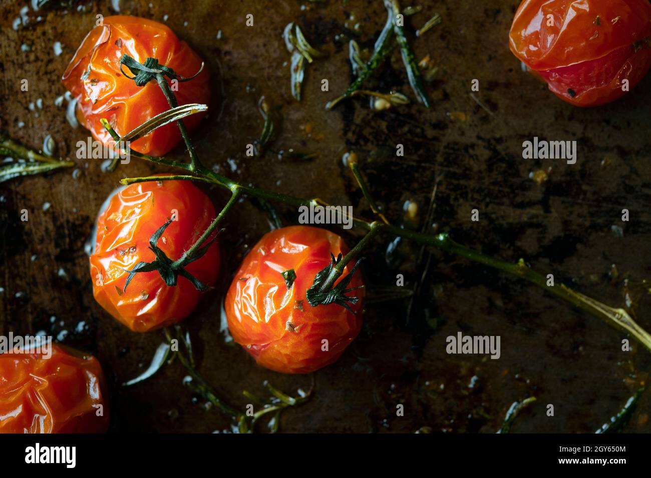 Pomodori maturati con vite arrostiti su una teglia da forno Foto Stock