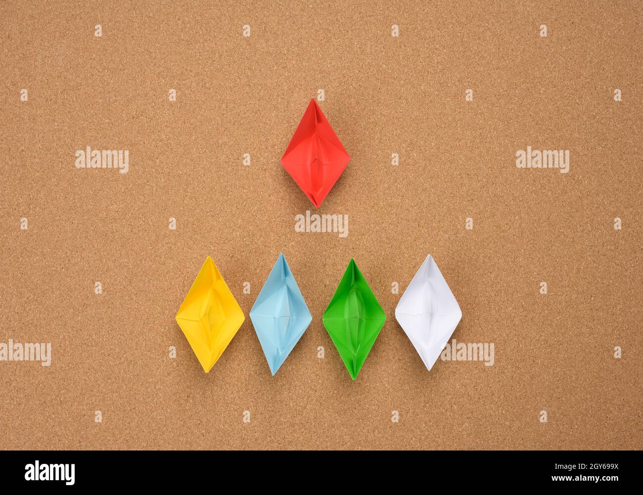gruppo di barche di carta e uno rosso su sfondo abrown. Il concetto di un leader forte, la manipolazione delle masse, un team stretto e un uomo efficace Foto Stock
