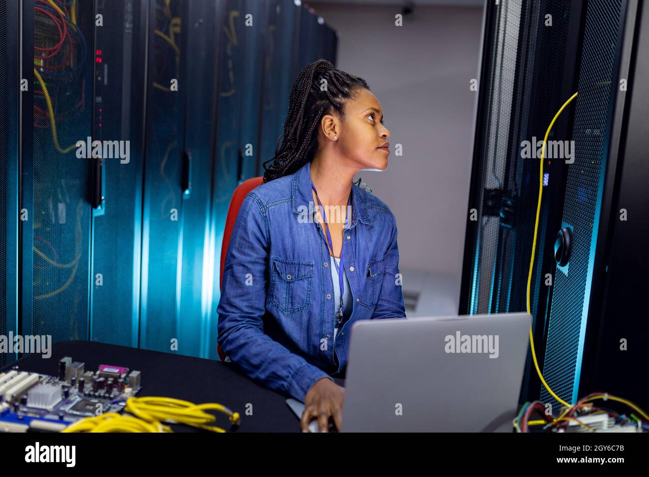 Tecnico di computer femminile afro-americano che utilizza un computer portatile che lavora nella sala server Foto Stock