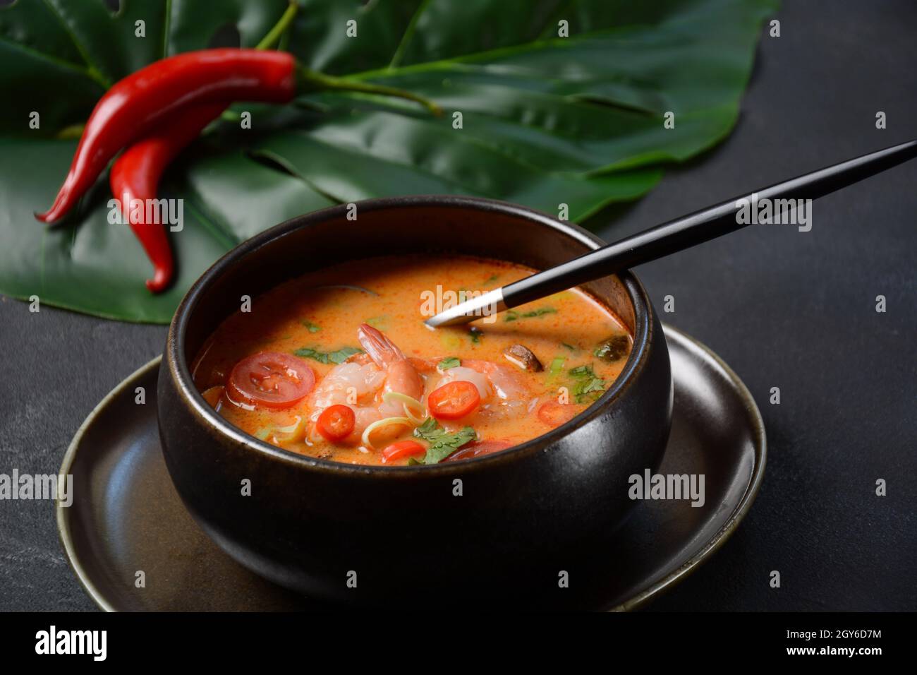 Tom Yam kung zuppa tailandese piccante con gamberi, latte di cocco e peperoncino in ciotola. Foto Stock