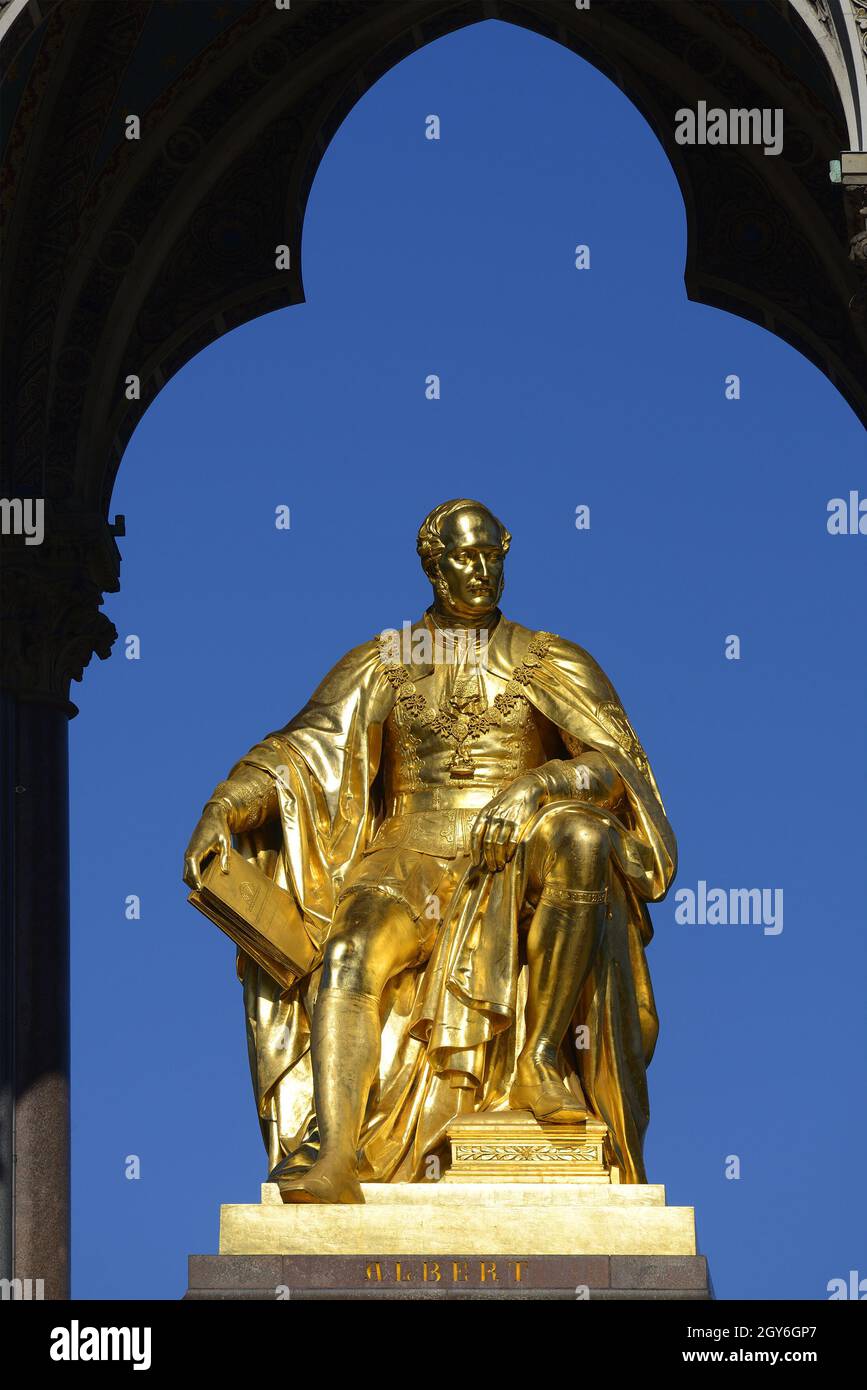 Londra, Inghilterra, Regno Unito. Albert Memorial (1872: George Gilbert Scott) a Kensington Gardens. Statua di Gilden del principe Alberto che tiene il catalogo del G. Foto Stock