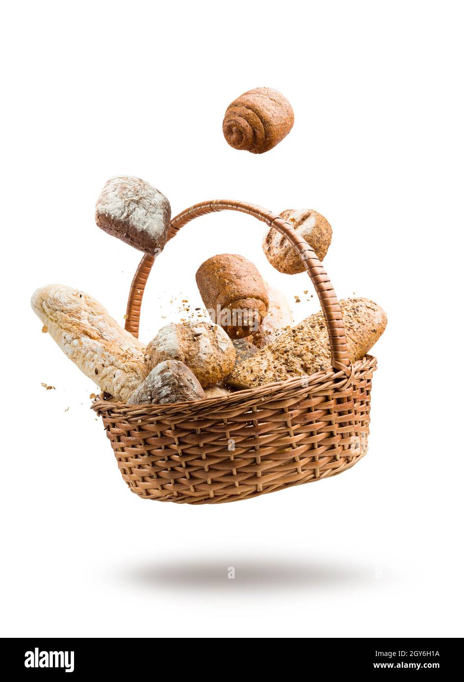 cestino di vimini con vari tipi di pane che saltano su sfondo bianco Foto Stock