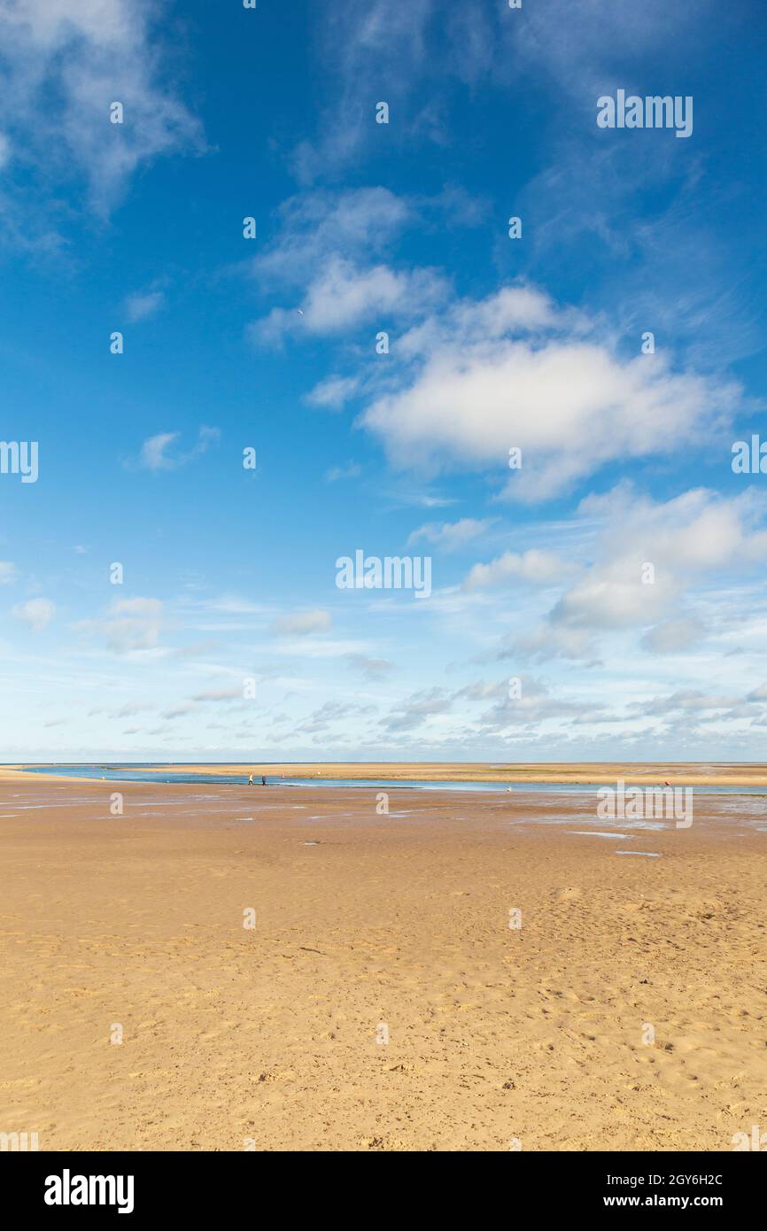 Ampia distesa di spiaggia e cielo a Holkham Bay, Wells-Next-the-Sea a North Norfolk in una mattinata di ottobre luminosa e soleggiata con People Walking Foto Stock