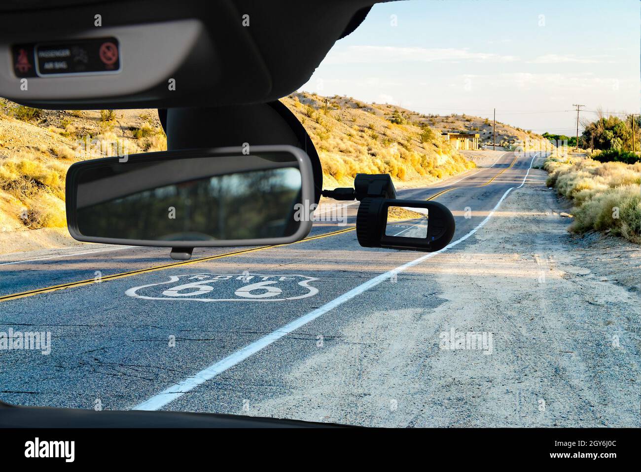 Guardando attraverso un auto dashcam telecamera montata su un parabrezza con vista sulla storica Route 66, con pavimentazione sign in California, Stati Uniti d'America Foto Stock