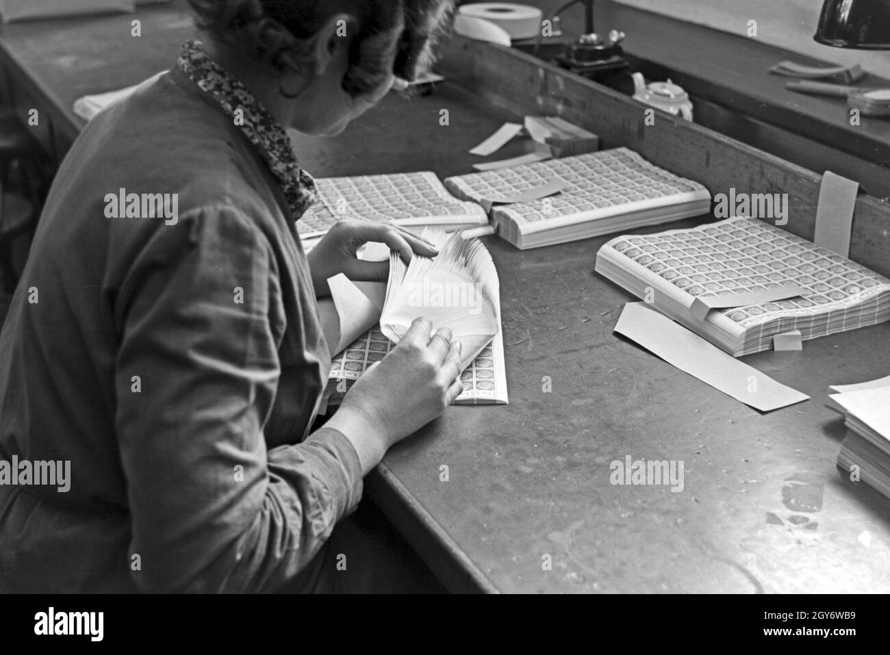 Eine Mitarbeiterin der Reichsdruckerei zählt Hindenburg Dauerserie Briefmarken in Bögen a Berlino, Deutschland 1930er Jahr. Un personale femminile membro della stampa Reichsdruckerei stabilimento di Berlino Hindenburg conteggio fogli timbro, Germania 1930s. Foto Stock