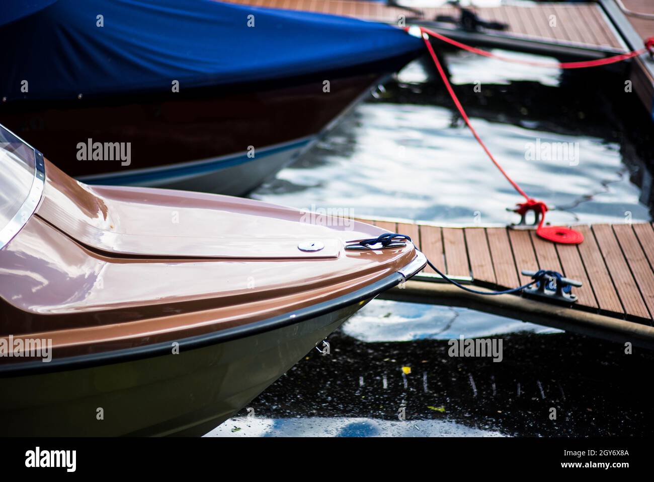 Piccola barca a motore all'ancora con la corda nel molo di Replot. Foto Stock