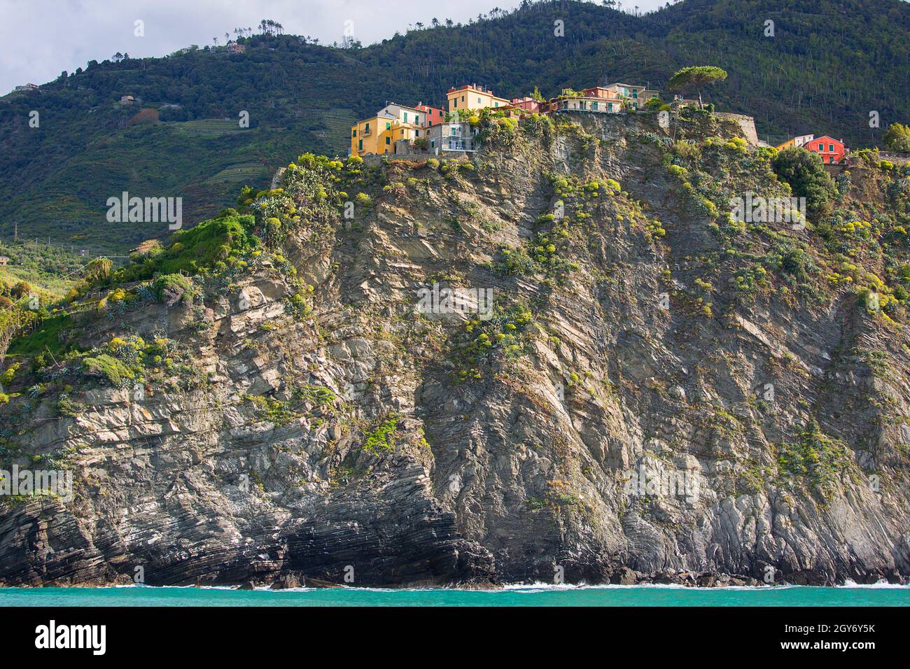 Vista sul mare e piccolo villaggio su una collina rocciosa, case tipiche colorate, Corniglia, cinque Terre, Italia Foto Stock