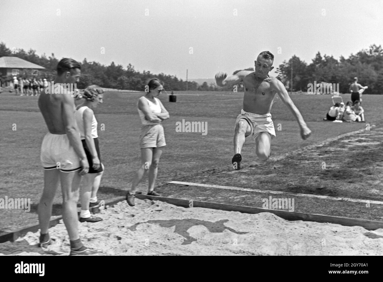 Übung im Weitsprung auf dem Sportplatz des KdF Sportheim Belzig in der Mark Brandenburg, Deutschland 1930er Jahre. Salto in lungo esercizio presso il campo sportivo dello sports club house a Belzig nel Brandeburgo, Germania 1930s. Foto Stock