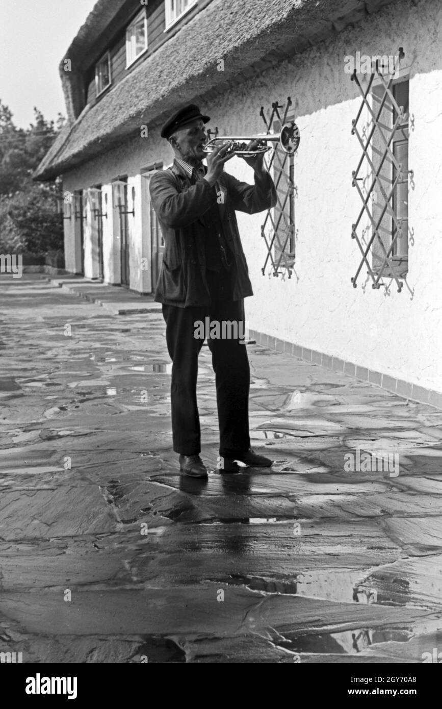 Der Hausmeister bläst zum Wecken im KdF Sportheim Belzig in der Mark Brandenburg, Deutschland 1930er Jahre. Bugle Boy facendo la chiamata di sveglia a sport club house a Belzig nel Brandeburgo, Germania 1930s. Foto Stock