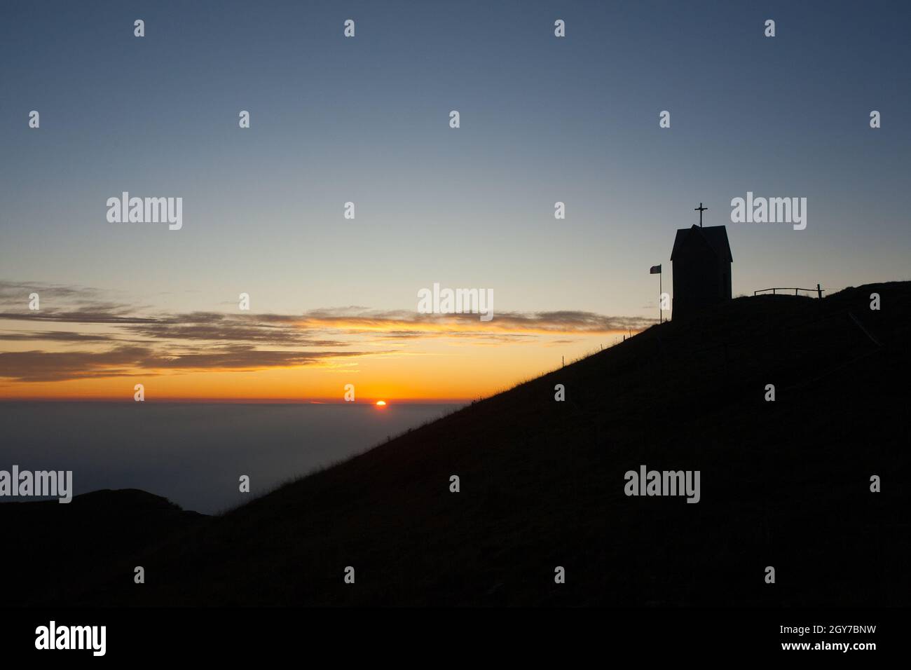 Alba alla piccola chiesa, Monte Grappa paesaggio, Italia. Alpi italiane panorama Foto Stock