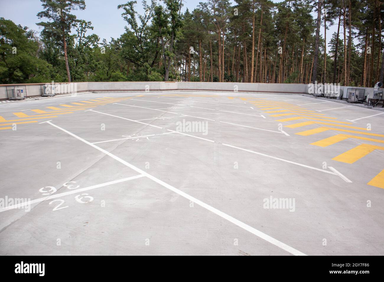 Parcheggio sul tetto vuoto. Le frecce direzionali e i parcheggi sono contrassegnati con vernice bianca e gialla sull'asfalto. Parcheggio senza auto Foto Stock