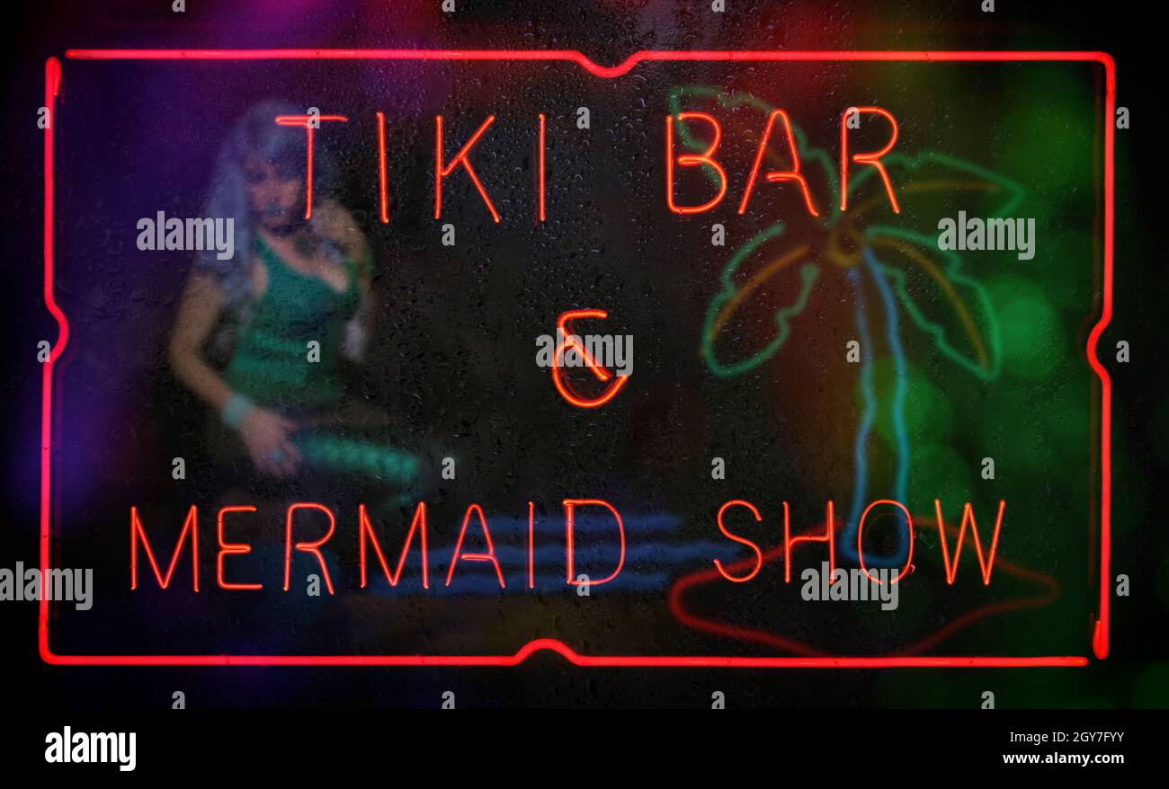 Neon Tiki Bar and Mermaid Show Neon Sign in Rainy Window Foto Stock