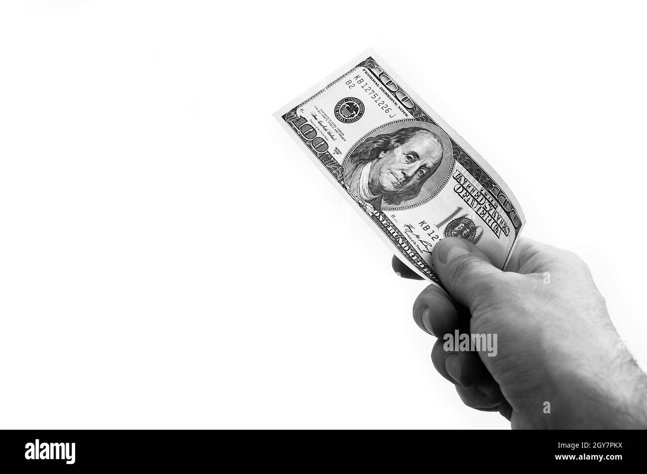 Un conto di cento dollari in mano su sfondo bianco. Isolato. In bianco e nero. Un conto di cento dollari americani. Una fattura è dollari. Il Foto Stock