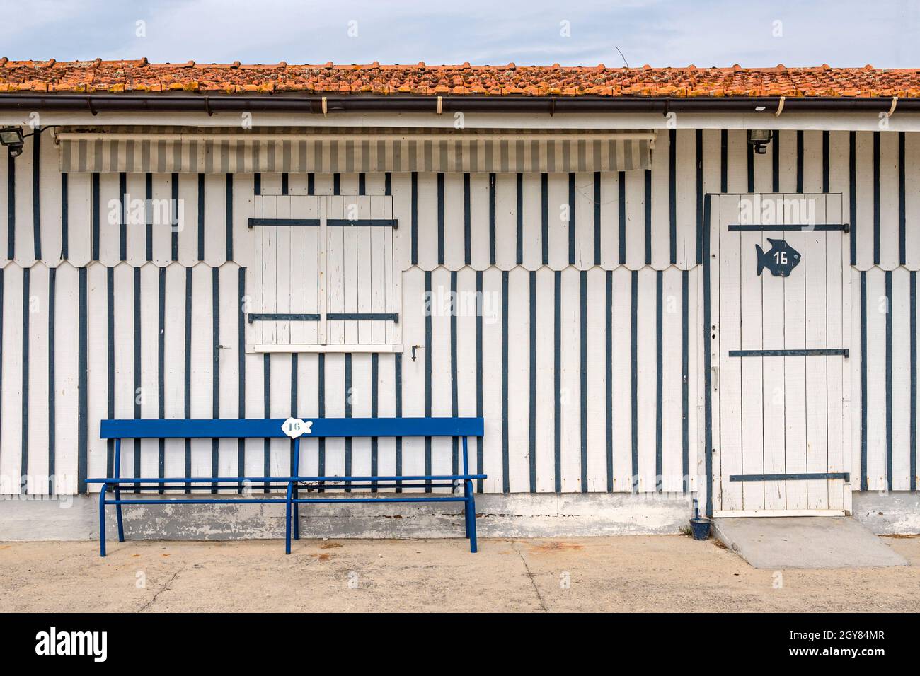 Le capanne del pescatore di ostriche sono tutte colorate decorate in strisce e confinano con il piccolo porto di Audenge, bassin d'Arcachon, Francia Foto Stock