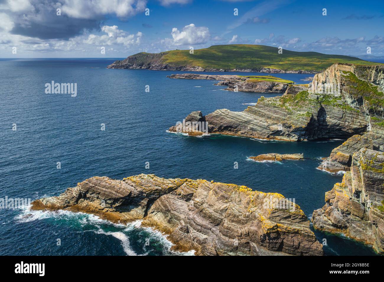 Scogliere di Kerry e acque turchesi dell'Oceano Atlantico illuminate dalla luce del sole e vista su Bray Head, Portmagee, penisola di Iveragh, Ring of Kerry, Irlanda Foto Stock