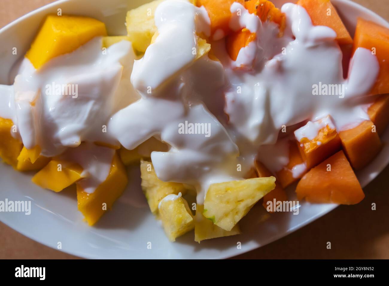 Piatto di frutta a fette con panna sulla parte superiore Foto Stock