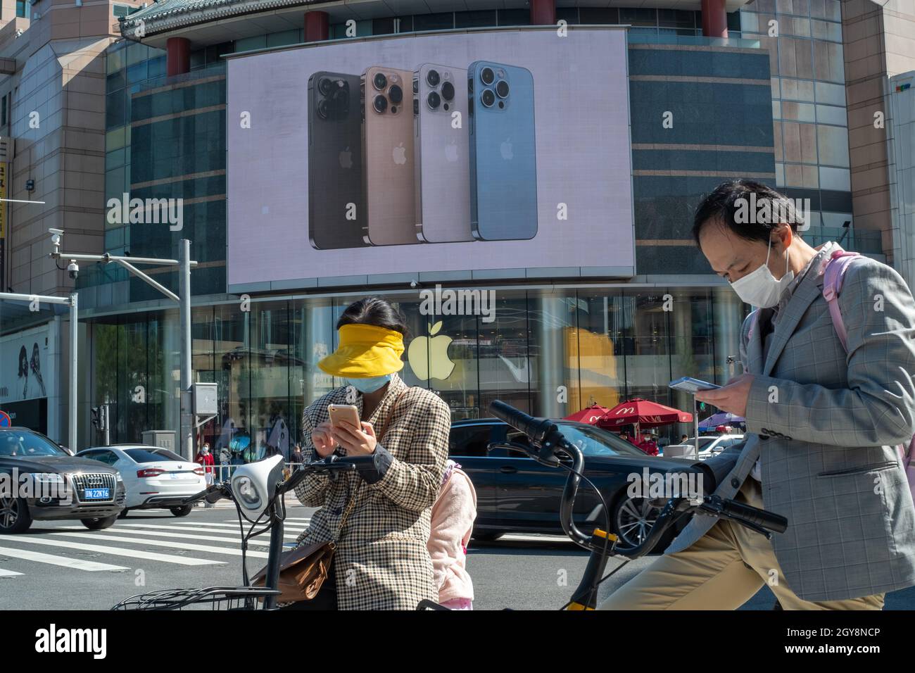 La gente cammina davanti a un negozio Apple a Wangfujing con la serie di pubblicità iPhone 13 su un grande schermo a Pechino, Cina. 07 ottobre 2021 Foto Stock